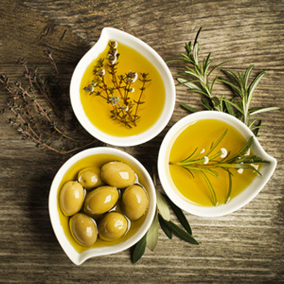 olive oil with fresh herbs on wooden background.